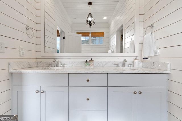 bathroom with vanity, wooden ceiling, and wooden walls