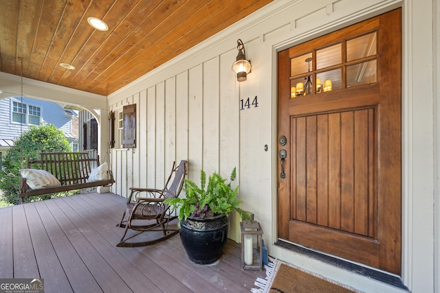 view of exterior entry featuring board and batten siding and a porch
