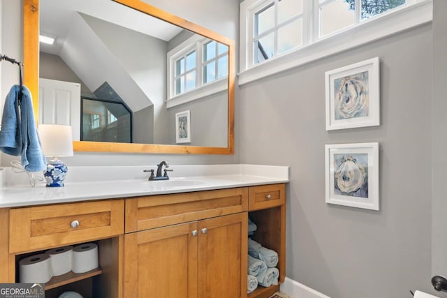 bathroom with baseboards, vaulted ceiling, vanity, and a shower with door
