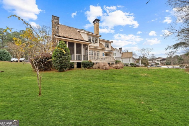 back of property featuring a sunroom and a lawn