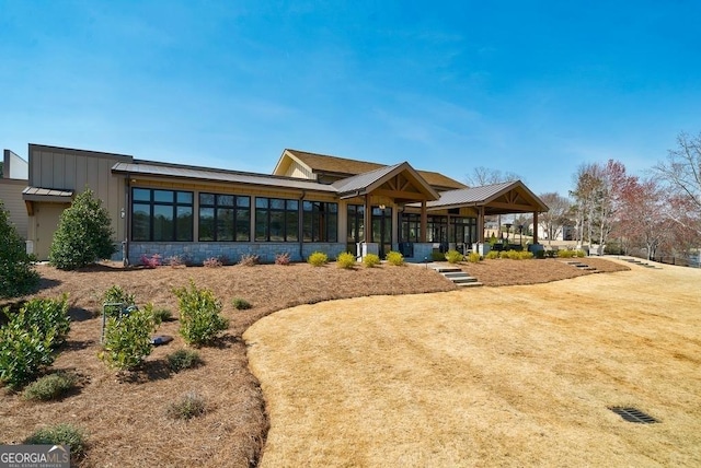 back of property featuring stone siding and a gazebo