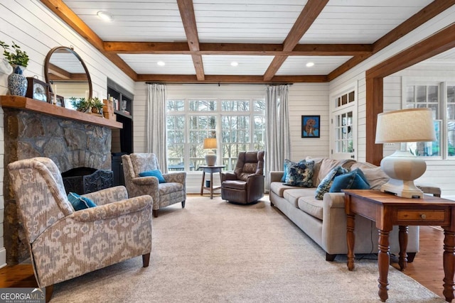 living room with a stone fireplace, wooden walls, beamed ceiling, and coffered ceiling