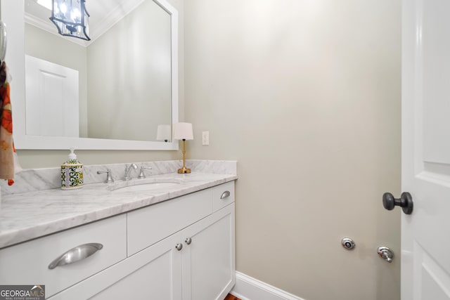 bathroom with baseboards, vanity, and crown molding