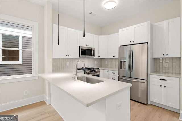 kitchen featuring white cabinetry, kitchen peninsula, and appliances with stainless steel finishes