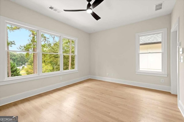 spare room featuring ceiling fan, a healthy amount of sunlight, and light wood-type flooring