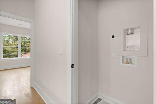 washroom with hookup for an electric dryer, hookup for a washing machine, and light hardwood / wood-style flooring