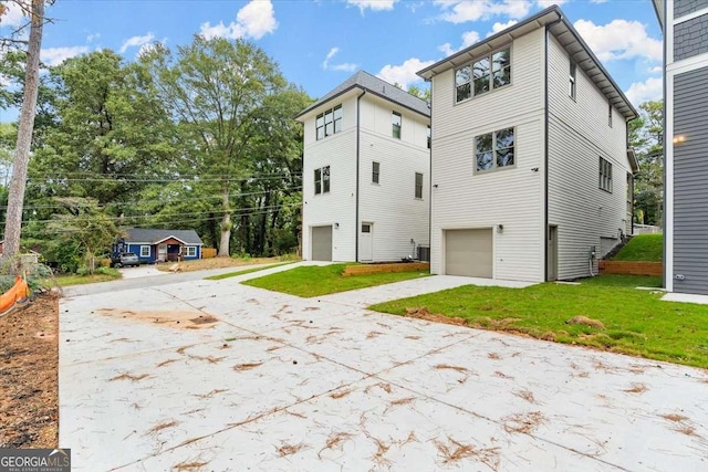 rear view of property with a yard and a garage