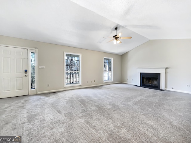 unfurnished living room with ceiling fan, carpet, and vaulted ceiling