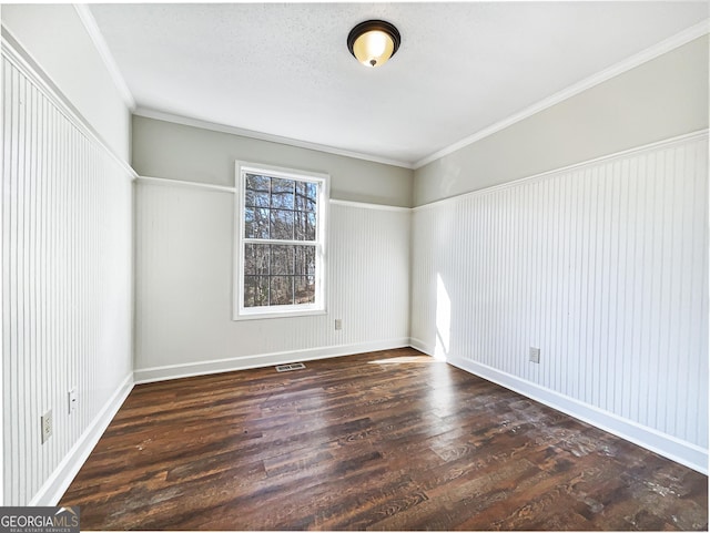 empty room with a textured ceiling, crown molding, and dark hardwood / wood-style floors