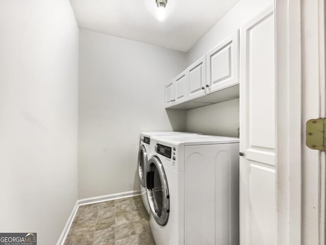 clothes washing area featuring washer and clothes dryer and cabinets