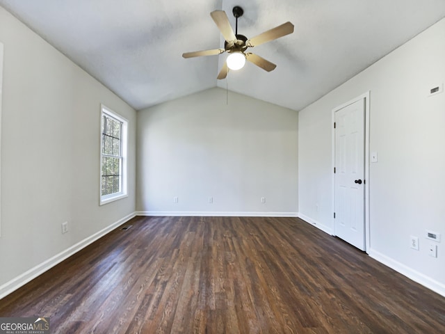 spare room featuring ceiling fan, dark hardwood / wood-style flooring, and vaulted ceiling