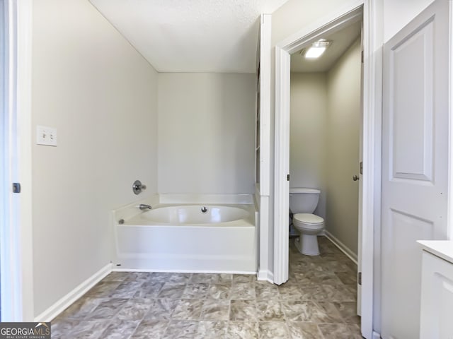 bathroom featuring a textured ceiling, vanity, toilet, and a bath