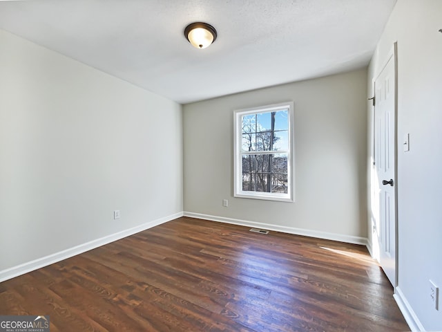 spare room featuring dark hardwood / wood-style flooring