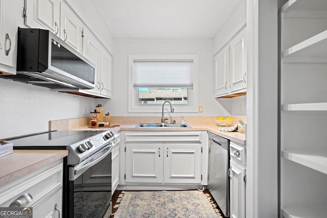 kitchen with white cabinets, appliances with stainless steel finishes, and sink