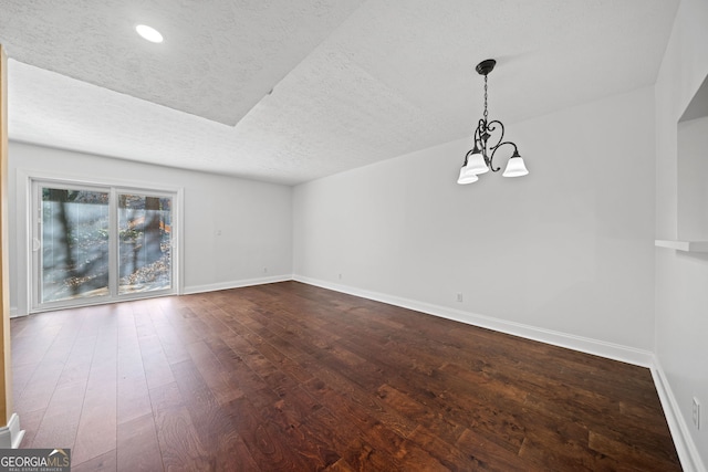 spare room with hardwood / wood-style flooring, a notable chandelier, and a textured ceiling