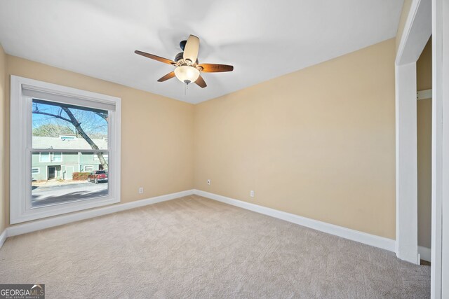 carpeted empty room featuring ceiling fan