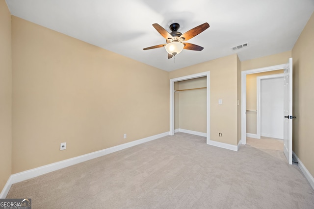 unfurnished bedroom featuring ceiling fan, a closet, and light colored carpet