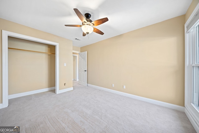 unfurnished bedroom with light carpet, a closet, and ceiling fan