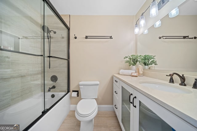 full bathroom with vanity, toilet, and bath / shower combo with glass door