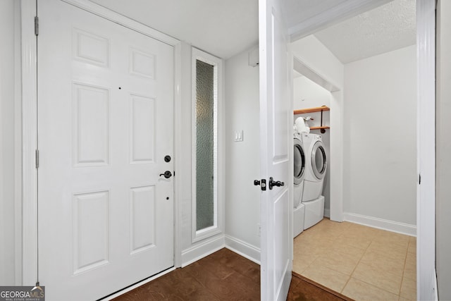 clothes washing area with a textured ceiling and washer and clothes dryer