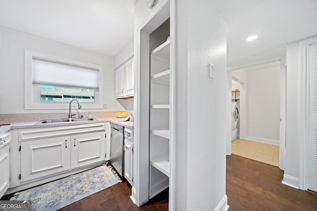 kitchen featuring sink, dark hardwood / wood-style flooring, stainless steel dishwasher, washer / clothes dryer, and white cabinets