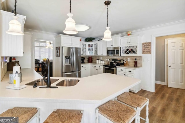 kitchen with stainless steel refrigerator with ice dispenser, sink, decorative light fixtures, white cabinets, and kitchen peninsula