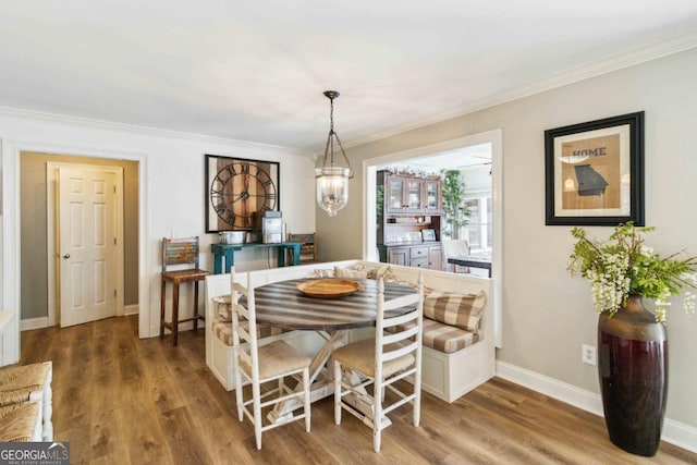 dining space featuring light hardwood / wood-style floors, ornamental molding, and ceiling fan