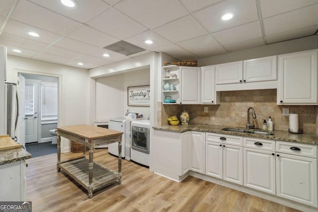 kitchen with sink, white cabinetry, a drop ceiling, and independent washer and dryer