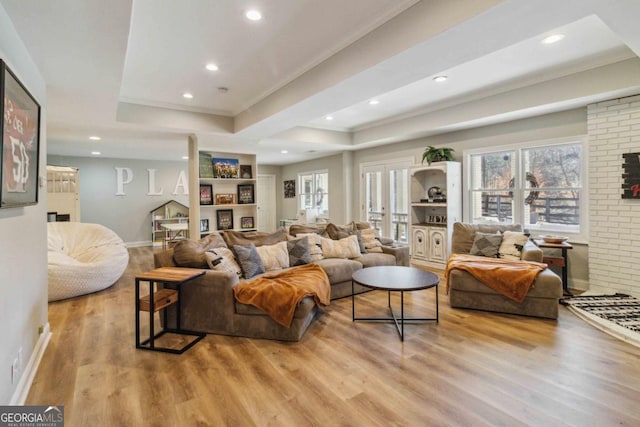 living room featuring light hardwood / wood-style floors and a raised ceiling