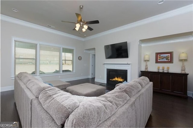 living room featuring dark wood-type flooring, ceiling fan, and crown molding