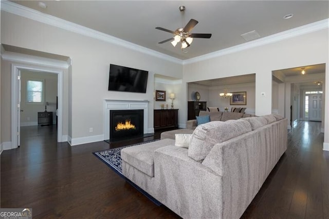 living room with ceiling fan with notable chandelier, crown molding, and dark wood-type flooring