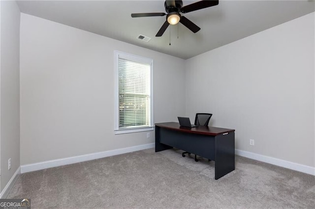 carpeted home office featuring ceiling fan