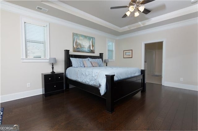 bedroom with ceiling fan, a raised ceiling, crown molding, and dark wood-type flooring