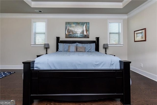 bedroom with dark hardwood / wood-style flooring, a raised ceiling, and crown molding