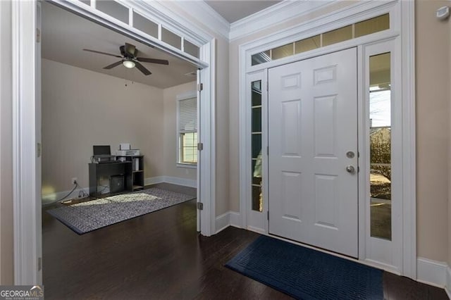 foyer entrance with dark wood-type flooring, plenty of natural light, crown molding, and ceiling fan