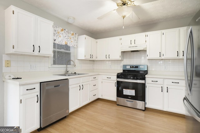 kitchen featuring sink, light hardwood / wood-style flooring, ceiling fan, appliances with stainless steel finishes, and white cabinetry