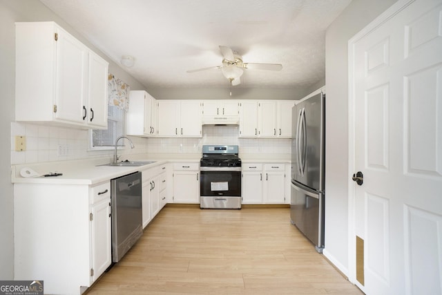 kitchen with white cabinetry, sink, stainless steel appliances, tasteful backsplash, and light wood-type flooring