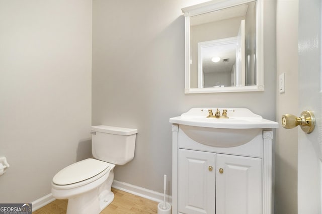 bathroom with vanity, toilet, and wood-type flooring