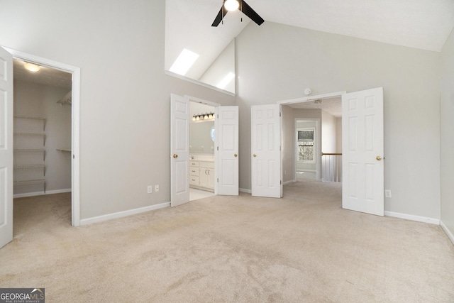 unfurnished bedroom featuring a spacious closet, a closet, ceiling fan, and high vaulted ceiling