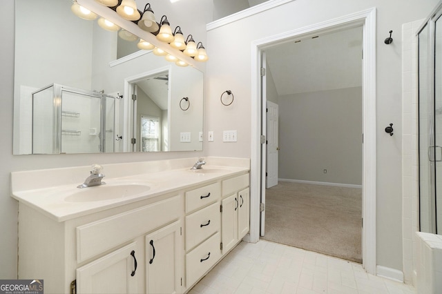 bathroom with vanity, a shower with shower door, and vaulted ceiling