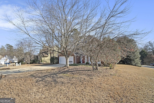 view of property hidden behind natural elements featuring a garage