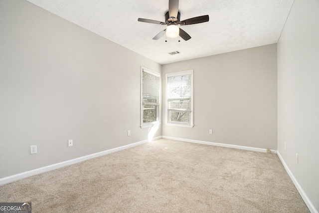 carpeted empty room with a textured ceiling and ceiling fan