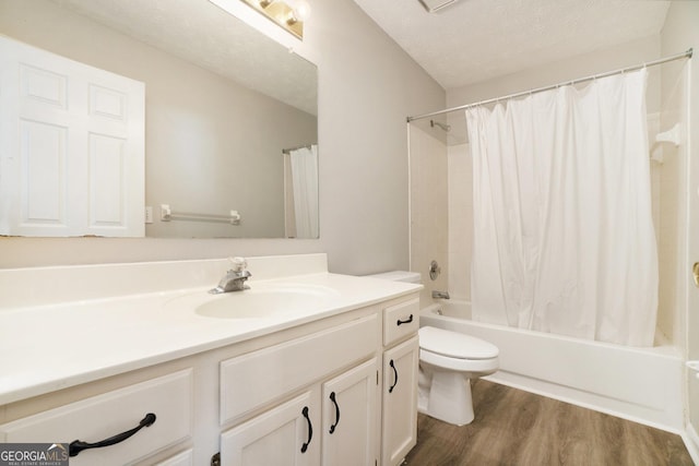 full bathroom featuring shower / bathtub combination with curtain, hardwood / wood-style floors, a textured ceiling, toilet, and vanity