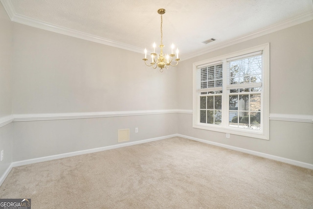 carpeted spare room featuring ornamental molding and a notable chandelier