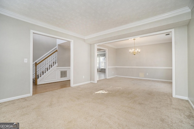 carpeted empty room with crown molding, a textured ceiling, and a notable chandelier