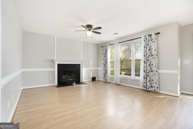 unfurnished living room with ceiling fan, a textured ceiling, and light hardwood / wood-style flooring