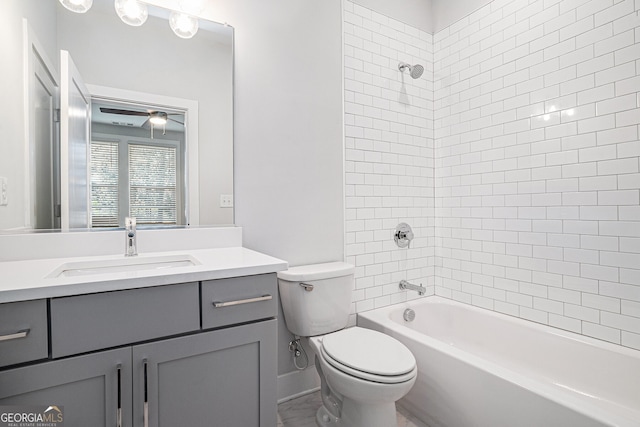 full bathroom featuring vanity, ceiling fan, tiled shower / bath, and toilet