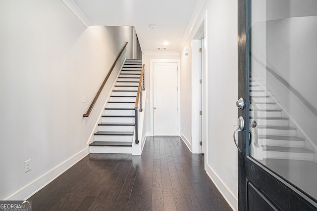 foyer with ornamental molding and dark wood-type flooring