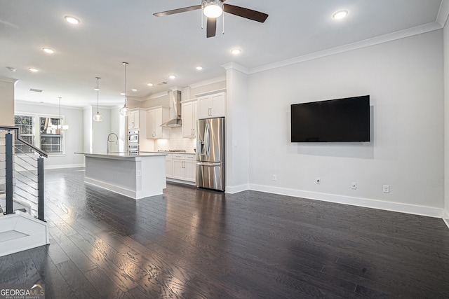 unfurnished living room featuring ceiling fan, sink, crown molding, and dark hardwood / wood-style floors