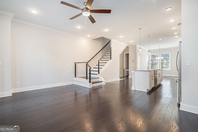 unfurnished living room featuring dark hardwood / wood-style flooring, ceiling fan, crown molding, and sink